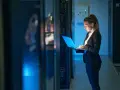 Mujer con portátil en centro de datos, gestionando infraestructura como servicio (IaaS) y soluciones SOC as a service.