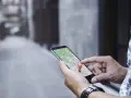 Hombre usando su móvil para localizar una persona por móvil en un mapa.