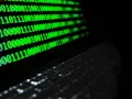 Código binario verde en pantalla, reflejando un teclado. ¿Qué es idp.generic? Es la base de la información digital.