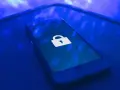 Teléfono móvil con un candado blanco en la pantalla, símbolo de seguridad. Aprende como proteger mi móvil de hackers.