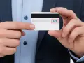 Un hombre muestra una tarjeta de crédito, destacando el número 135, que representa que es el CVV de una tarjeta.
