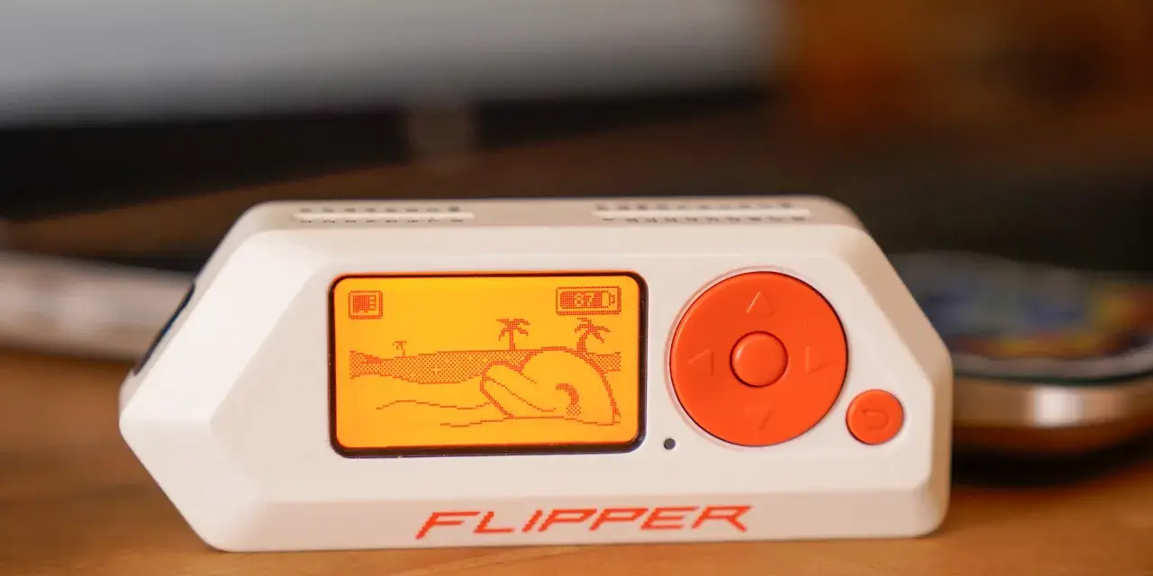 El Flipper Zero, un dispositivo portátil con pantalla naranja que muestra una escena de playa, es una herramienta versátil para explorar la tecnología.