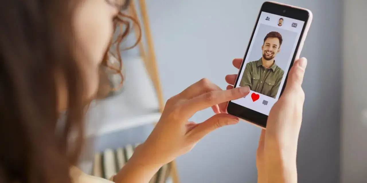 Mujer revisa un perfil en una app de citas, ¿será uno de los tantos perfiles falsos de Meetic?