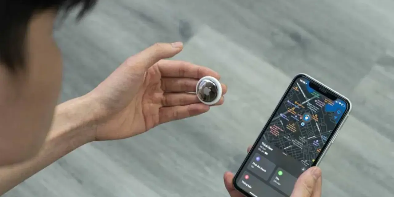 Persona revisa un AirTag y un iPhone con mapa. Aprende como saber si rastrean mi iPhone con esta tecnología.