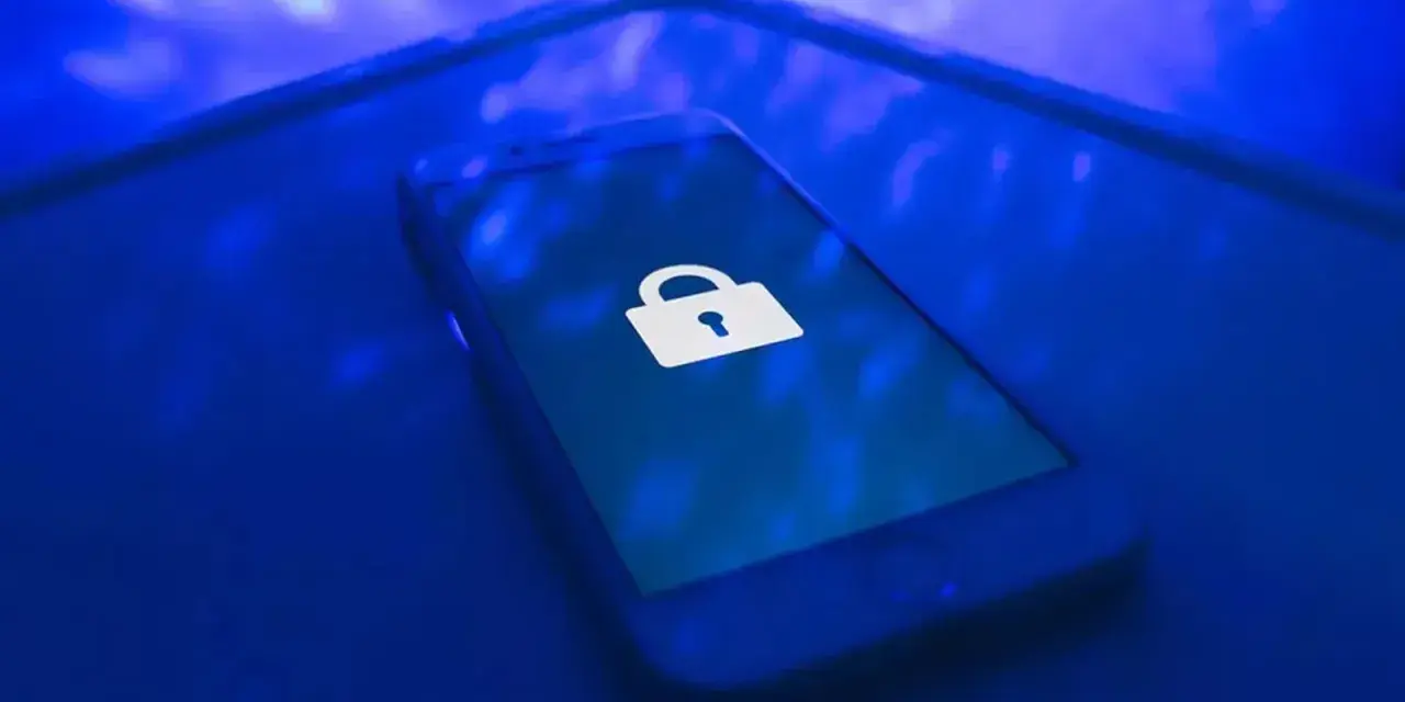 Teléfono móvil con un candado blanco en la pantalla, símbolo de seguridad. Aprende como proteger mi móvil de hackers.