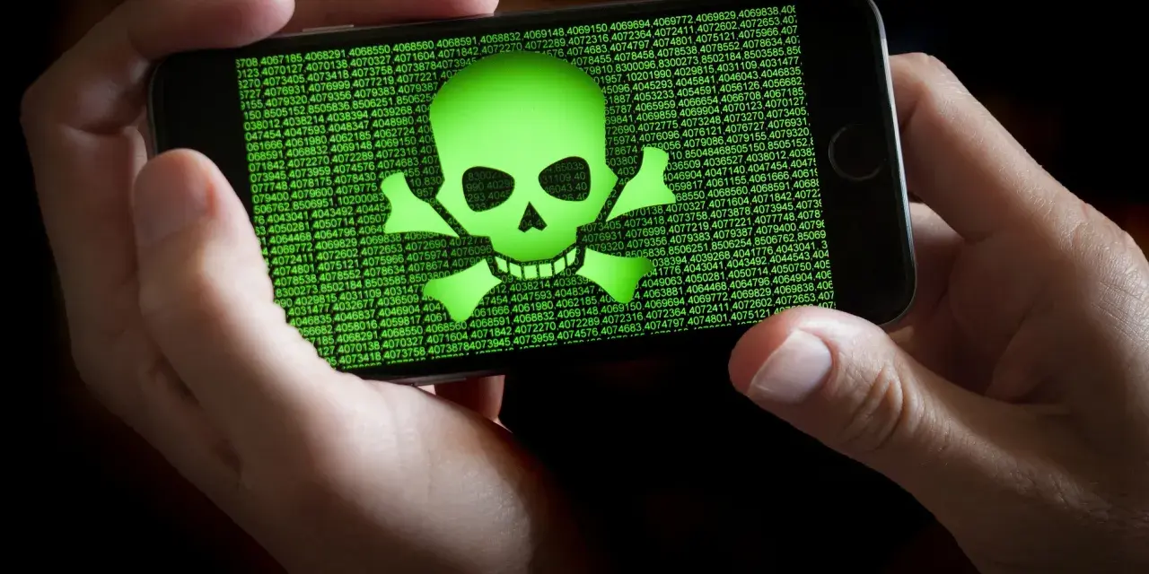 Teléfono mostrando calavera verde y números. Alguien intenta escanear virus movil.