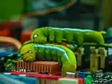Dos orugas verdes se arrastran sobre una placa base, como un gusano ciberseguridad que busca vulnerabilidades.