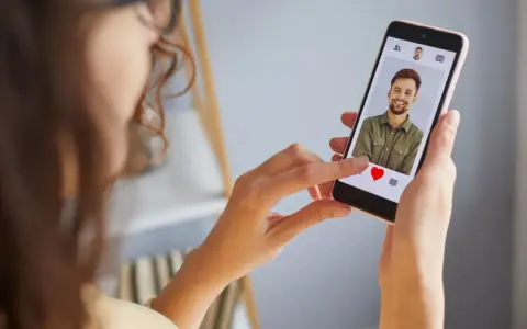 Mujer revisa un perfil en una app de citas, ¿será uno de los tantos perfiles falsos de Meetic?