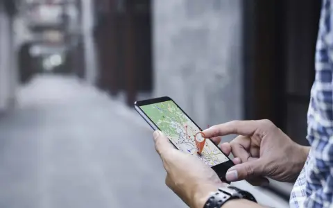 Hombre usando su móvil para localizar una persona por móvil en un mapa.