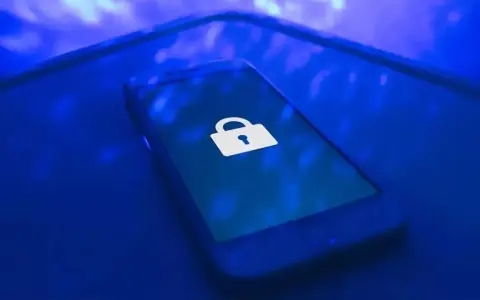 Teléfono móvil con un candado blanco en la pantalla, símbolo de seguridad. Aprende como proteger mi móvil de hackers.