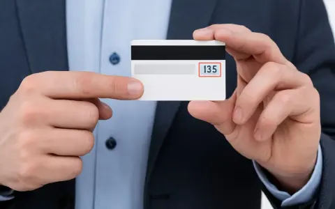 Un hombre muestra una tarjeta de crédito, destacando el número 135, que representa que es el CVV de una tarjeta.