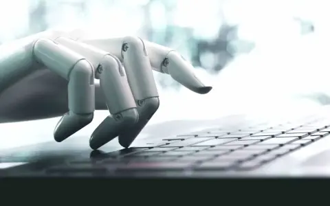 Mano robótica escribiendo en un teclado, una imagen que ilustra qué son los bots y su interacción con la tecnología.