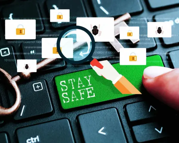 Un dedo presiona "STAY SAFE" en un teclado. Iconos de sobres con candados y arañas sugieren un enlace seguro y amenazas.