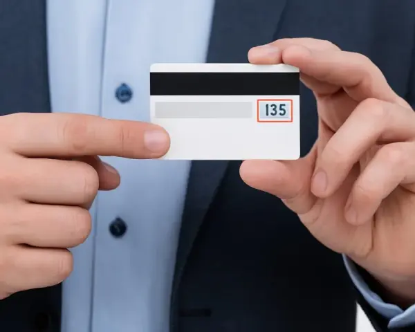 Un hombre muestra una tarjeta de crédito, destacando el número 135, que representa que es el CVV de una tarjeta.