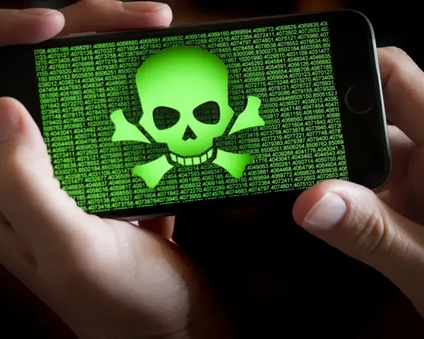 Teléfono mostrando calavera verde y números. Alguien intenta escanear virus movil.