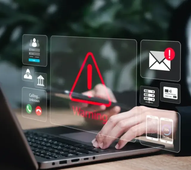Alerta de seguridad digital: un mensaje falso podría estar acechando. Iconos de advertencia, correo, tarjetas y teléfonos flotan sobre un portátil.