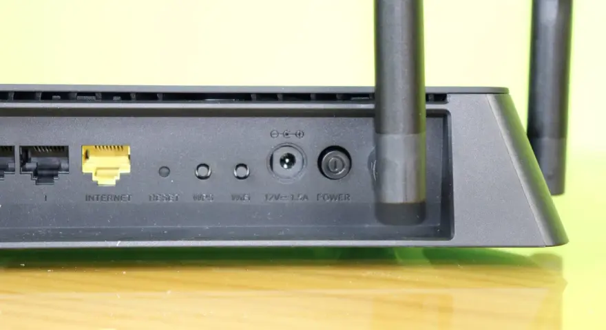 Detalle de un router con puertos Ethernet, botón de reinicio y conexión de energía. Ideal para quienes necesitan reiniciar router.