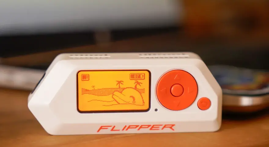 El Flipper Zero, un dispositivo portátil con pantalla naranja que muestra una escena de playa, es una herramienta versátil para explorar la tecnología.