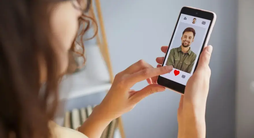 Mujer revisa un perfil en una app de citas, ¿será uno de los tantos perfiles falsos de Meetic?