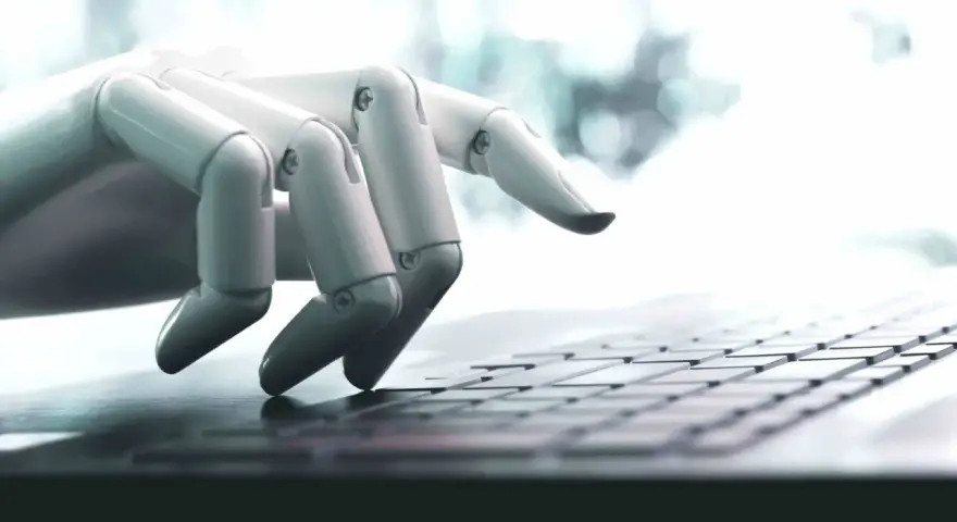 Mano robótica escribiendo en un teclado, una imagen que ilustra qué son los bots y su interacción con la tecnología.