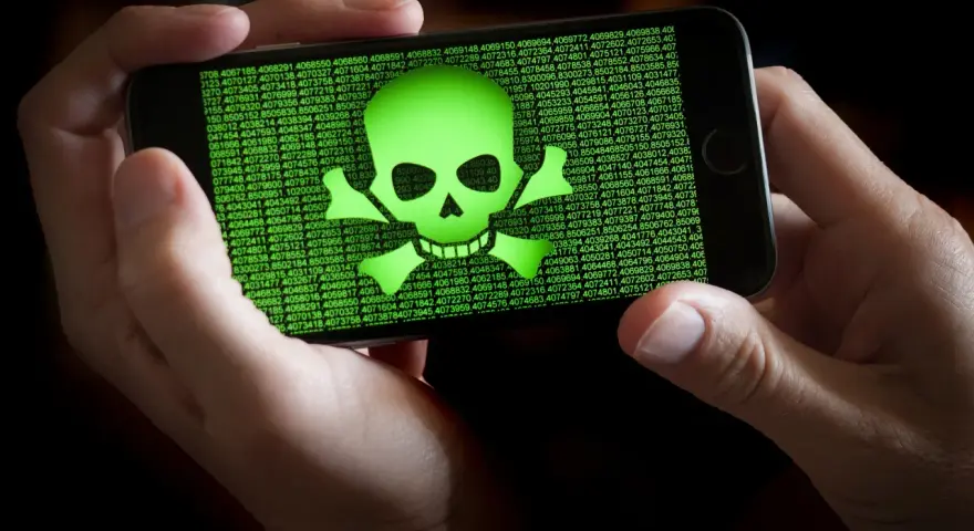 Teléfono mostrando calavera verde y números. Alguien intenta escanear virus movil.