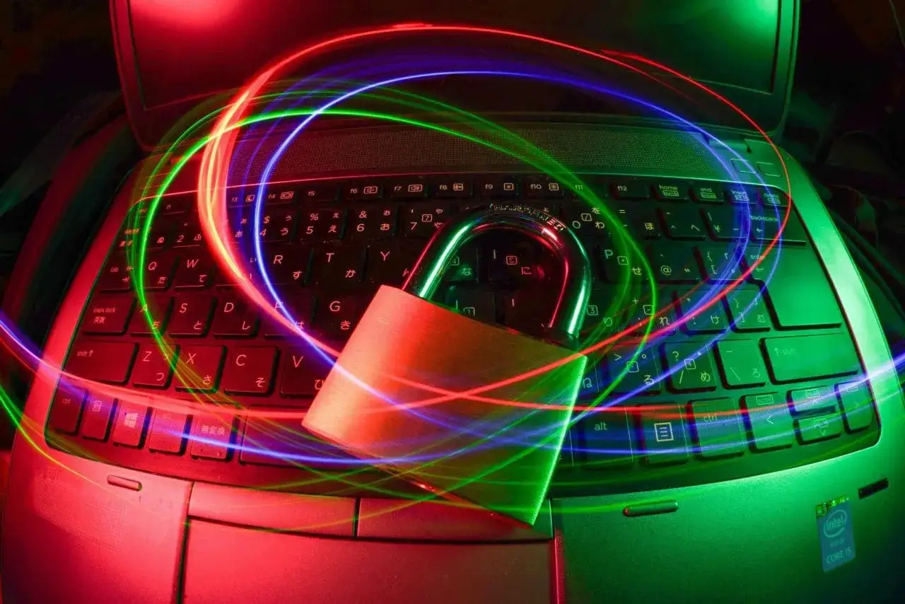 Candado sobre teclado de port&aacute;til con luces de ne&oacute;n. Aprende como usar wifislax para seguridad.