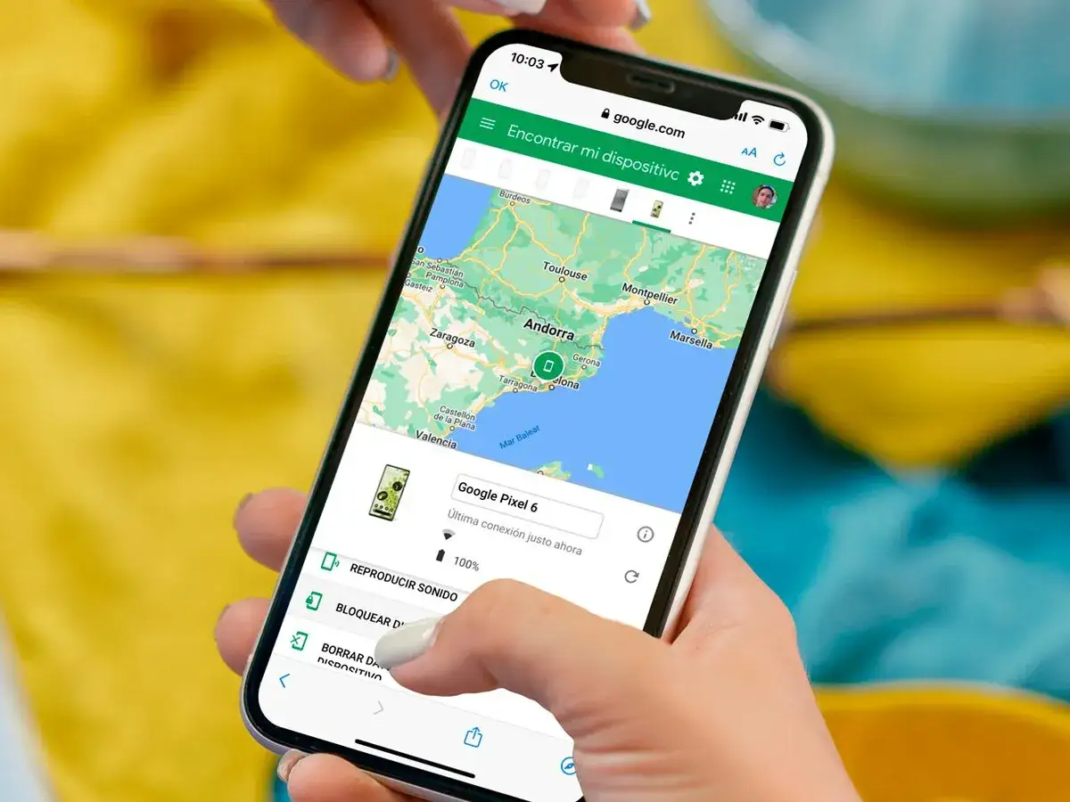 Mano sujetando un móvil con el localizador de dispositivos Android abierto, mostrando un mapa de España y Francia y opciones para el Google Pixel 6.