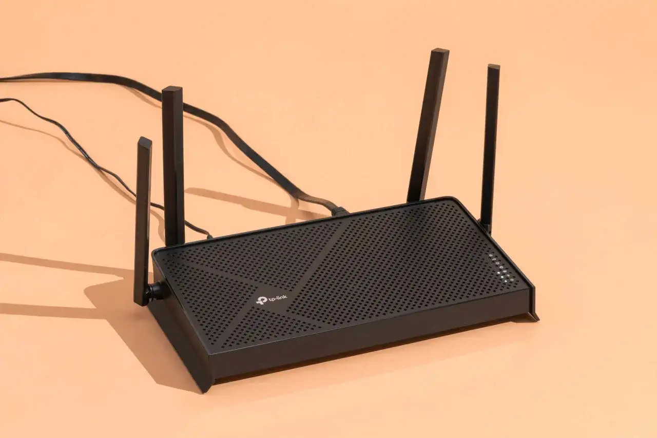 Un router negro con antenas, listo para conectar tu hogar a internet.