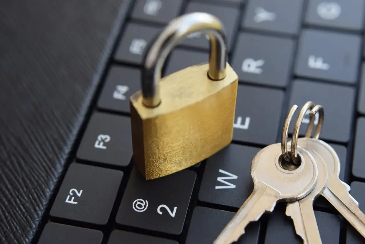 Candado dorado y llaves sobre un teclado, simbolizando un enlace seguro y protección de datos.